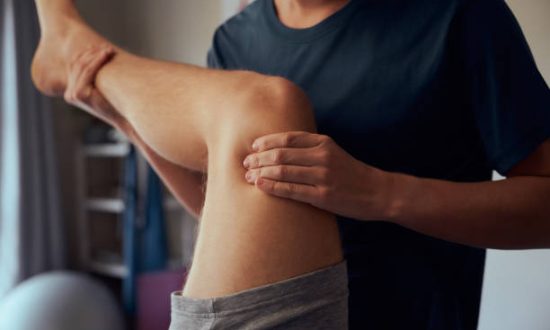 Doctor hands giving physiotherapy to patient knee Doctor hands giving physiotherapy to patient knee