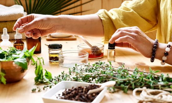natural_medicine Woman prepares aromatherapy session at the table with essential oil diffuser medical herbs, different types of oils and essences. Aromatherapy and alternative medicine concept. Natural remedies.